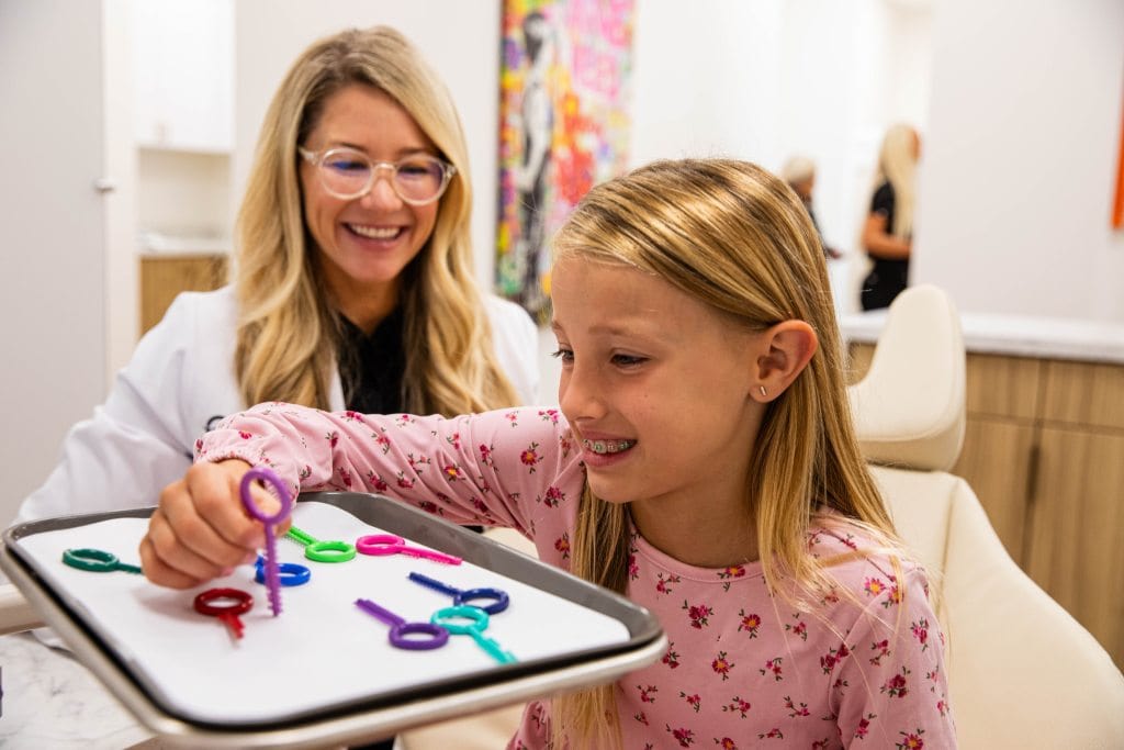 Dr. Otto talking to little girl with braces